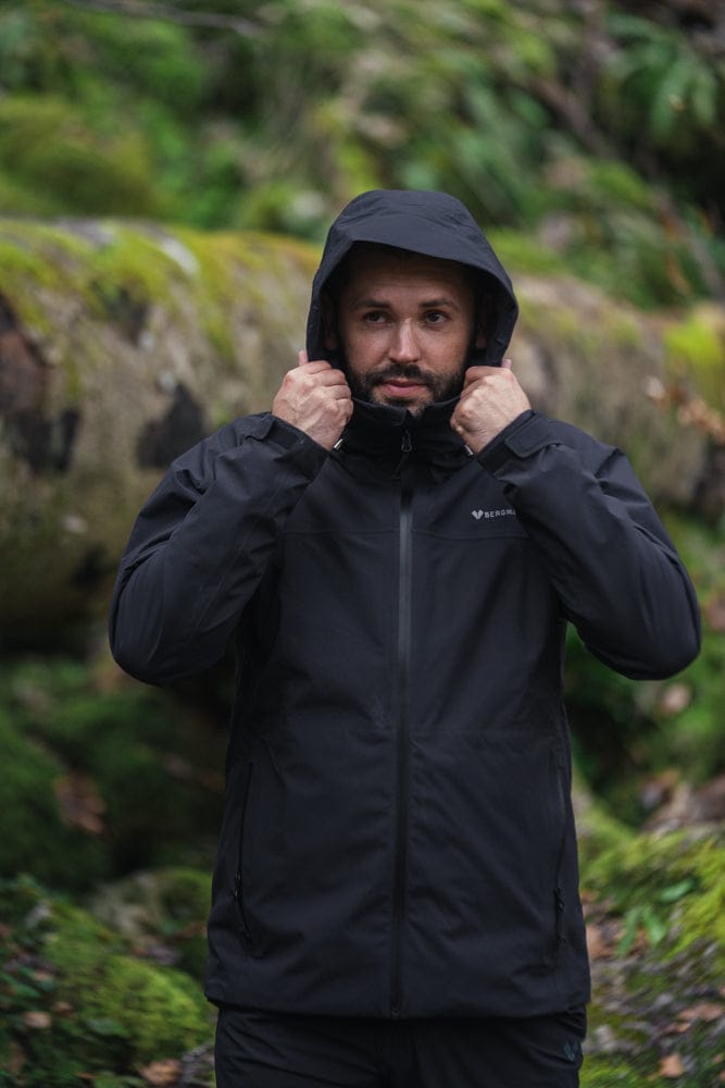 Model trägt BERGMENSCH Herren 3L Hardshell Regenjacke in der Farbe Black