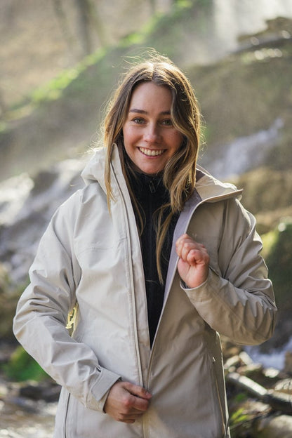 Model trägt BERGMENSCH Damen 3L Hardshell Regenjacke in der Farbe Whitecap Grey
