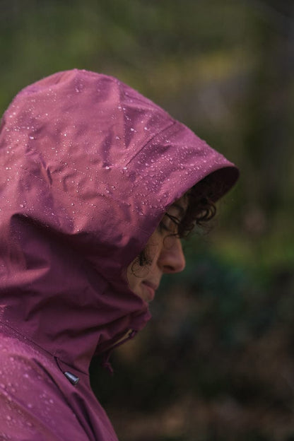 Model trägt BERGMENSCH Damen 3L Hardshell Regenjacke in der Farbe Hibiscus