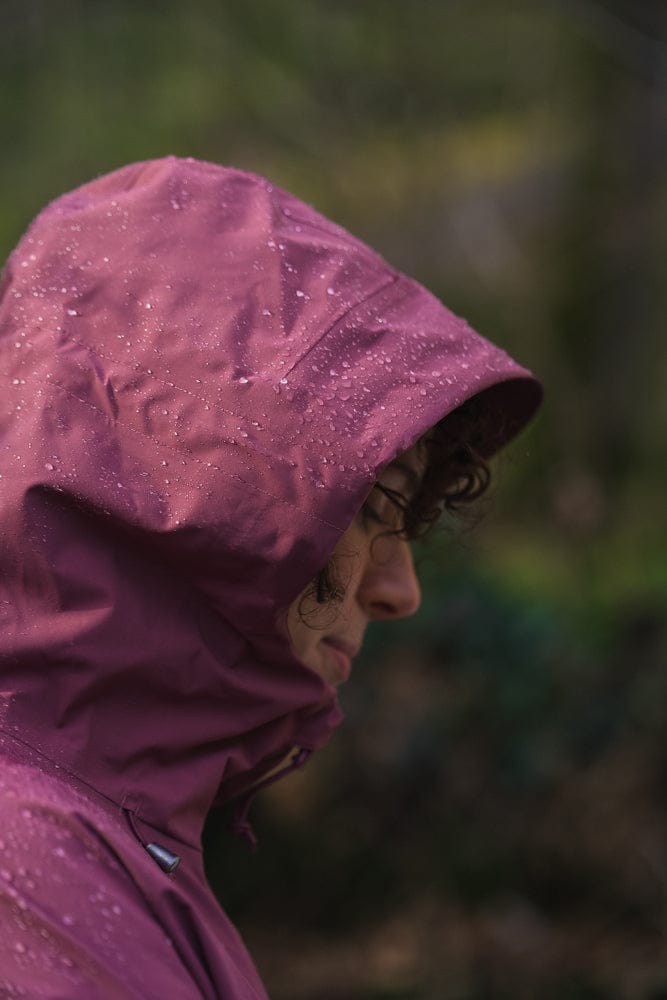 Model trägt BERGMENSCH Damen 3L Hardshell Regenjacke in der Farbe Hibiscus