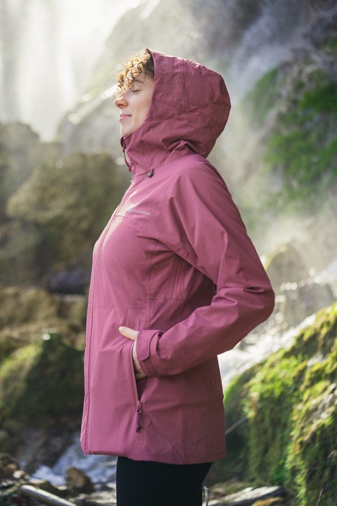 Model trägt BERGMENSCH Damen 3L Hardshell Regenjacke in der Farbe Hibiscus