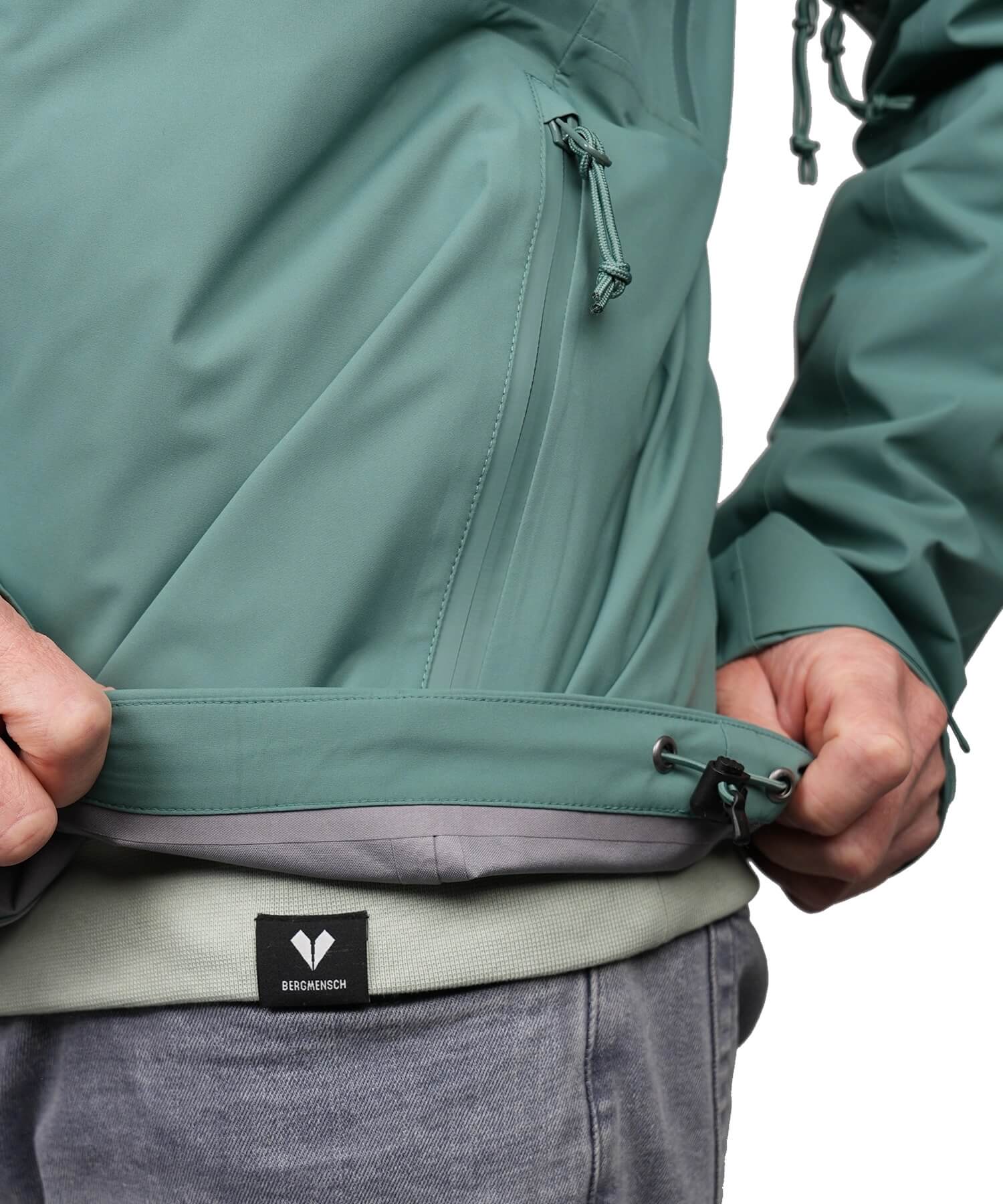 Detailansicht Saumzug der BERGMENSCH Herren 3-Lagen Regenjacke in der Farbe Deep Lake